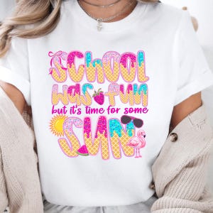 May include: White t-shirt with a pink, blue, and yellow graphic that says "School was fun but it's time for some sun". The graphic features a strawberry, sunglasses, a watermelon, a flamingo, and a sun.