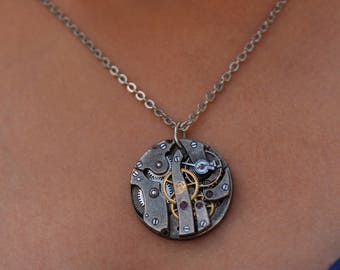 Colgante de collar de movimiento Steampunk Reloj Hecho a mano vintage victoriano reciclado de moda y bisutería reciclada con engranajes expuestos.