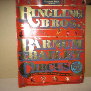 May include: A red and gold program for the Ringling Bros. and Barnum & Bailey Circus. The program features a globe with the text "World's Greatest Show" and the text "Exotic Attractions From Around The World".