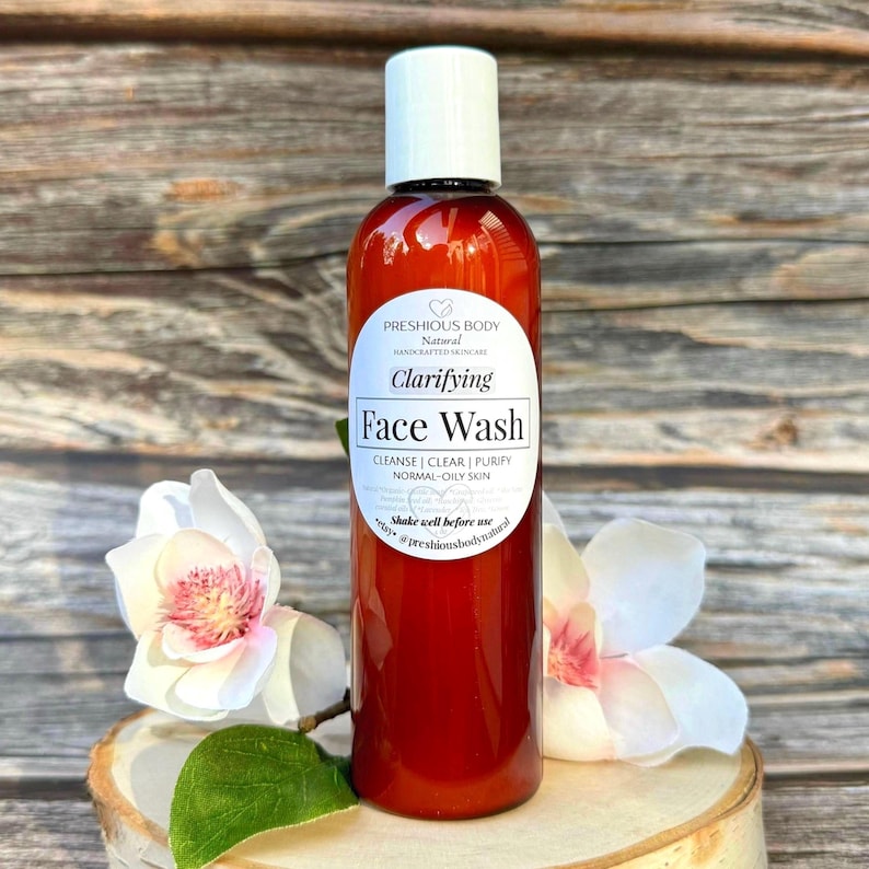 A brown bottle of clarifying face wash with a white label that reads 'Preshious Body Natural Handcrafted Skincare Clarifying Face Wash Cleanse | Clear | Purify Normal-Oily Skin Shake well before use etsy @preshiousbodynatural'.