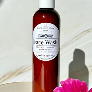 A brown bottle of clarifying face wash with a white label that reads 'Preshious Body Natural Handcrafted Skincare Clarifying Face Wash Cleanse | Clear | Purify Normal-Oily Skin Shake well before use etsy @preshiousbodynatural'.