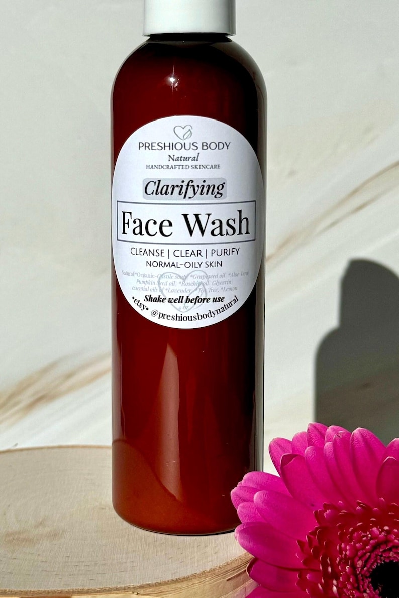 A brown bottle of clarifying face wash with a white label that reads 'Preshious Body Natural Handcrafted Skincare Clarifying Face Wash Cleanse | Clear | Purify Normal-Oily Skin Shake well before use etsy @preshiousbodynatural'.