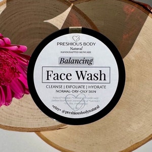 Puede incluir: Un tarro negro con una etiqueta blanca que dice "PRESHIOUS BODY Natural HANDCRAFTED SKINCARE Balancing Face Wash CLEANSE | EXFOLIATE | HYDRATE NORMAL-DRY-OILY SKIN Natural *Organic* Coconut oil, Castile soap, Sodium bicarbonate, essential oils of Lavender, Tea Tree, Frankincense etsy @preshiousbodynatural"