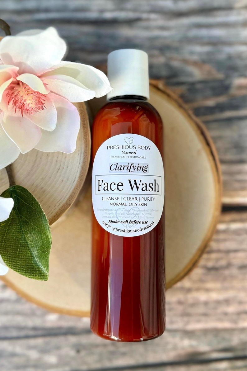 A brown bottle of clarifying face wash with a white label that reads 'Preshious Body Natural Handcrafted Skincare Clarifying Face Wash Cleanse | Clear | Purify Normal-Oily Skin Shake well before use etsy @preshiousbodynatural'.