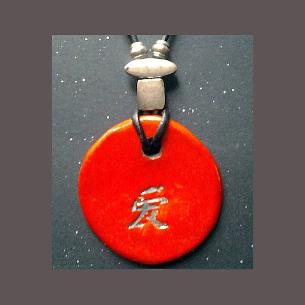 Pendentif en raku rouge avec signe chinois monté sur collier cuir noir avec attache métal