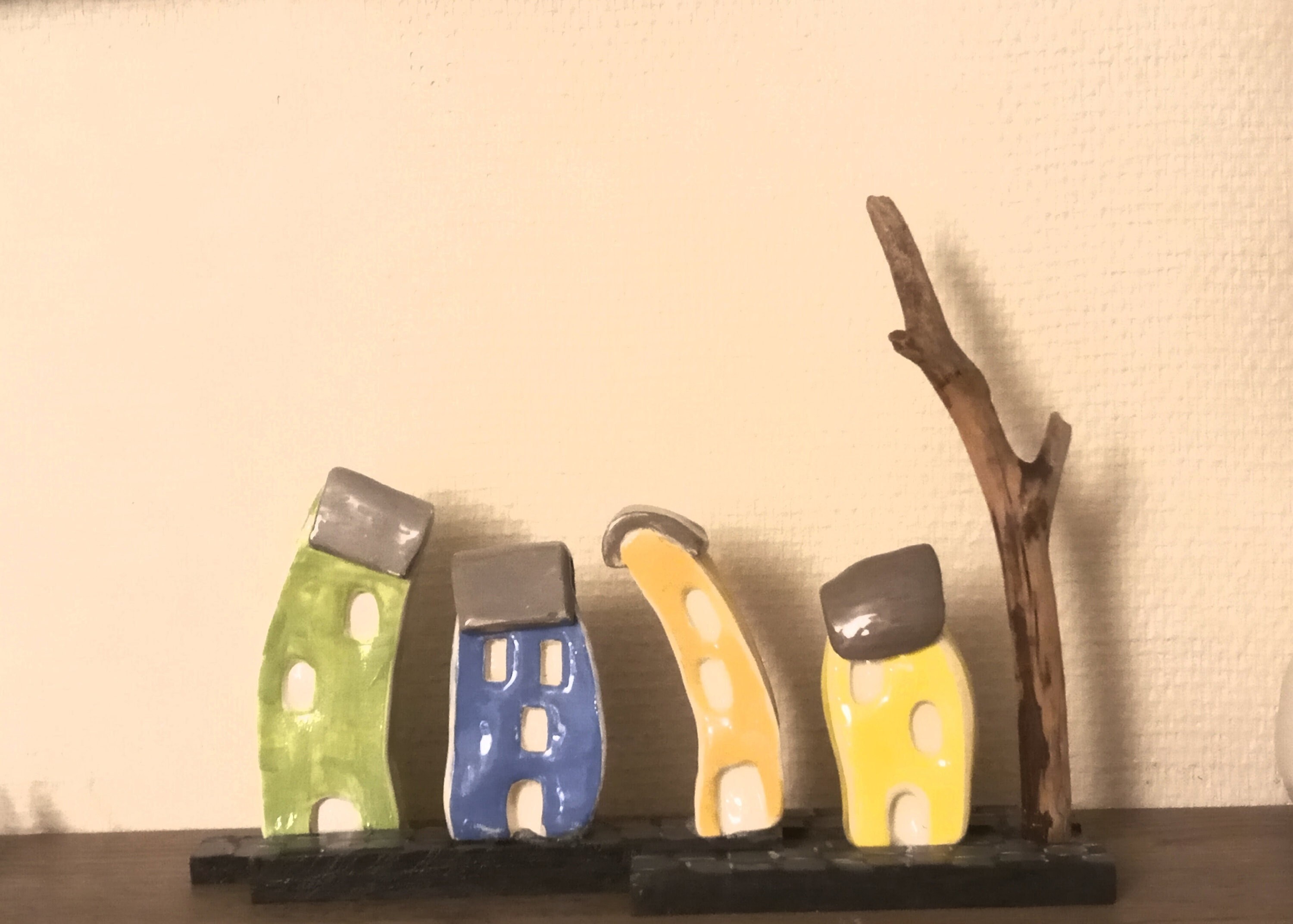 Un Petit Village Biscornu avec 4 Maisonnettes Émaillées sur Des Pavés Un Arbre en Bois Flotté.