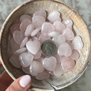 Puede incluir: Un bol lleno de piedras de cuarzo rosa en forma de coraz&oacute;n. El bol est&aacute; hecho de madera clara y tiene un acabado natural. Se incluye una moneda de 25 centavos de d&oacute;lar estadounidense para la escala.