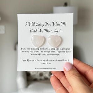 Puede incluir: Dos peque&ntilde;as piedras de cuarzo rosa en forma de coraz&oacute;n rosa sobre una tarjeta blanca con el texto "I Will Carry You With Me Until We Meet Again". La tarjeta tambi&eacute;n incluye el texto "Bury one in loving memory & keep the other near, that way you know I'm always here. Together these stones will keep us connected. Rose Quartz is the stone of unconditional love & connection. CaseysCrystalCove.Etsy.com"