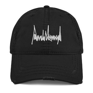 Peut inclure: Une casquette de baseball noire us&eacute;e avec une signature brod&eacute;e blanche qui lit "Donald Trump".