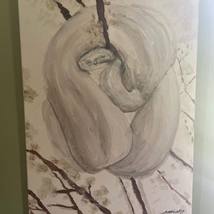 May include: A rectangular canvas painting depicting a light gray snake coiled around a dark brown branch. The background features pale, off-white blossoms on thin branches. The artist's signature and the date 3-17-23 are visible in the bottom right corner.