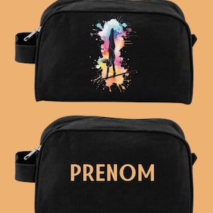 Peut inclure: Deux sacs de voyage à fermeture éclair en toile noire. Un sac présente un motif aquarelle coloré d'une gymnaste sur une barre. L'autre sac porte l'inscription "PRENOM" imprimée en orange.
