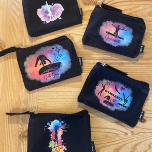 Puede incluir: Cinco bolsas negras con cremallera con diseños de acuarela coloridos que representan a gimnastas. Las bolsas tienen las palabras "Gymnaste", "Gymnastic Sport" y "Gymnastic Sport" impresas en ellas.