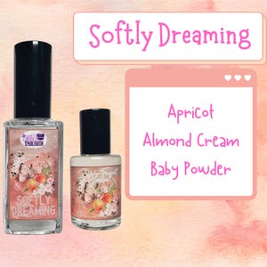 May include: Two glass bottles of perfume with a floral design and the text "Softly Dreaming". The bottles are on a pink and white background with the text "Apricot, Almond Cream, Baby Powder".