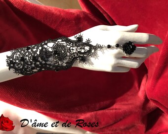 4 black rose ring hanging on a black lace bracelet