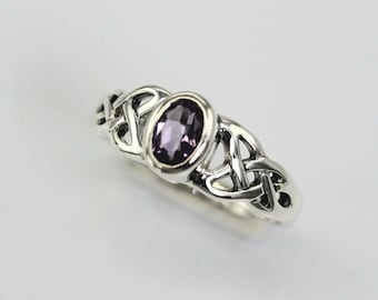 May include: A silver ring featuring a Celtic knot design and a purple gemstone in the centre.