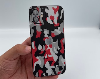 May include: A black iPhone case with a red, gray, and black camouflage pattern.