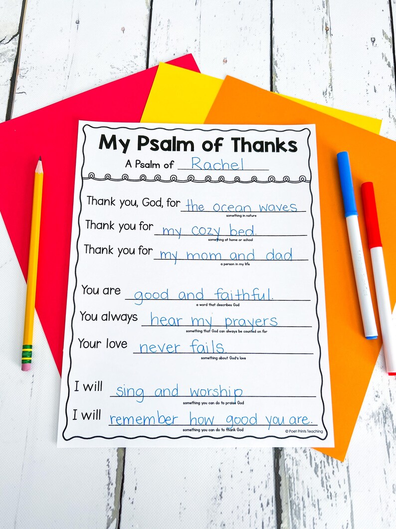 Op de afbeelding: Een wit, bedrukbaar werkblad met de titel "My Psalm of Thanks" met invullijnen. Het werkblad is omgeven door gekleurd papier en schrijfgerei, waaronder een gele potlood en blauwe en rode stiften.