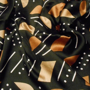 Puede incluir: Tela negra con un patr&oacute;n geom&eacute;trico de l&iacute;neas blancas, formas marrones y puntos blancos.