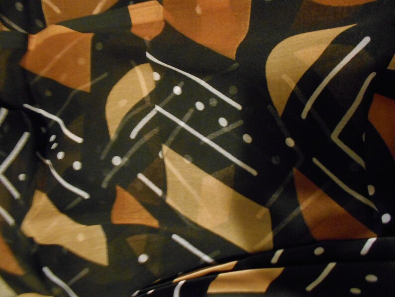 Puede incluir: Tela con estampado abstracto en negro, marr&oacute;n y blanco. La tela tiene un dise&ntilde;o geom&eacute;trico con formas y l&iacute;neas superpuestas.