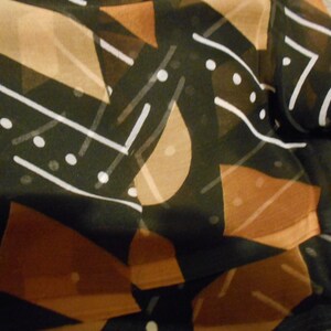 Puede incluir: Tela abstracta con fondo negro y formas geom&eacute;tricas marrones y blancas. La tela tiene una calidad transparente y transl&uacute;cida.