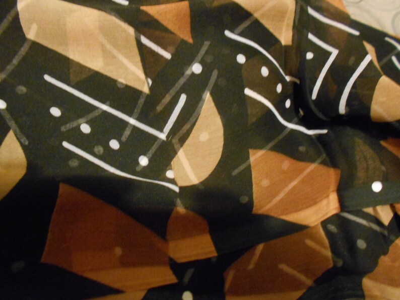 Puede incluir: Tela abstracta con fondo negro y formas geom&eacute;tricas marrones y blancas. La tela tiene una calidad transparente y transl&uacute;cida.