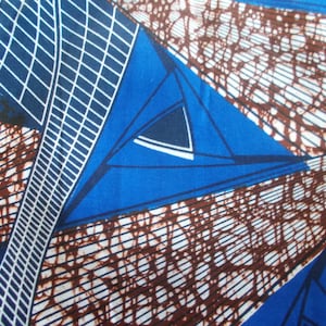 Peut inclure: Tissu abstrait avec un motif géométrique dans les tons de bleu, marron et blanc. Le tissu présente un motif répétitif de triangles et de lignes.