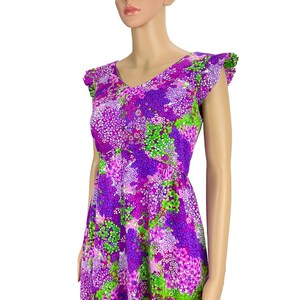 May include: A purple and green floral print dress with a V-neck and ruffled sleeves.