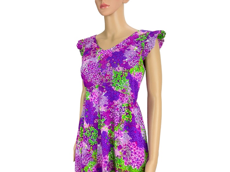 May include: A purple and green floral print dress with a V-neck and ruffled sleeves.