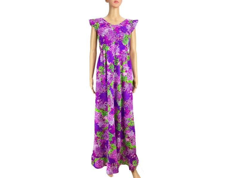 May include: A long purple dress with a green and pink floral print. The dress has short sleeves with ruffles and a gathered skirt.