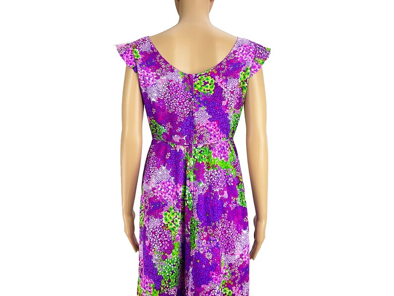May include: A purple and green floral print dress with short sleeves and a scoop neck.