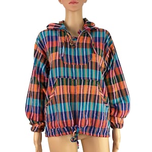May include: A colorful plaid hooded pullover shirt. The shirt features a drawstring hood, a front pocket, and long sleeves. The plaid pattern includes orange, teal, blue, and purple stripes. The shirt has wooden toggle closures.