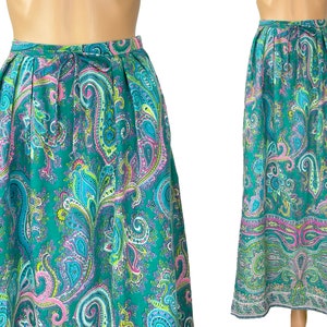 Puede incluir: Una falda larga y fluida con estampado paisley en tonos turquesa, rosa y verde. La falda tiene una cintura fruncida y un dobladillo ancho y fluido.