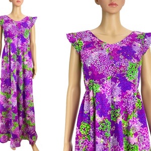 May include: A long purple maxi dress with a floral print featuring green, pink, and white flowers. The dress has a V-neckline and short, ruffled sleeves.