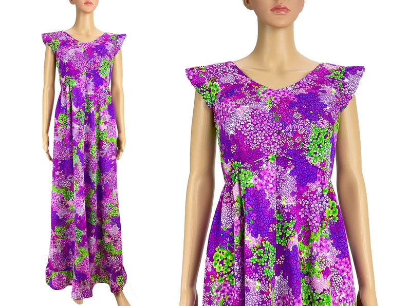 May include: A long purple maxi dress with a floral print featuring green, pink, and white flowers. The dress has a V-neckline and short, ruffled sleeves.