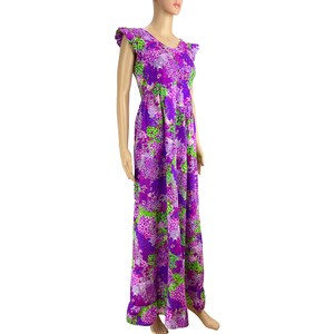 May include: A long purple maxi dress with a floral print featuring shades of pink, green, and purple. The dress has a V-neckline and short, ruffled sleeves.
