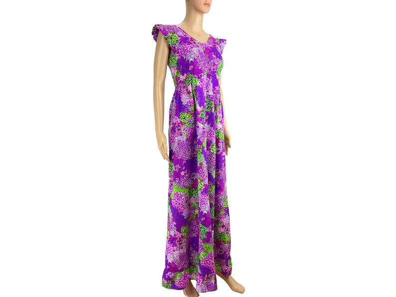 May include: A long purple maxi dress with a floral print featuring shades of pink, green, and purple. The dress has a V-neckline and short, ruffled sleeves.