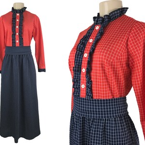 May include: A red and blue plaid dress with a ruffled collar and long sleeves. The dress has a fitted bodice and a full skirt.