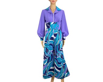 May include: A purple and blue jumpsuit with a long-sleeved top and a wide-legged bottom. The bottom features a geometric pattern of blue, purple, and white.