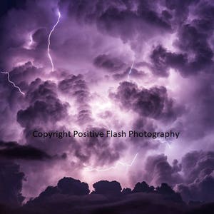 May include: A dramatic image of a dark purple sky with lightning bolts striking through the clouds. The image is titled "Copyright Positive Flash Photography".