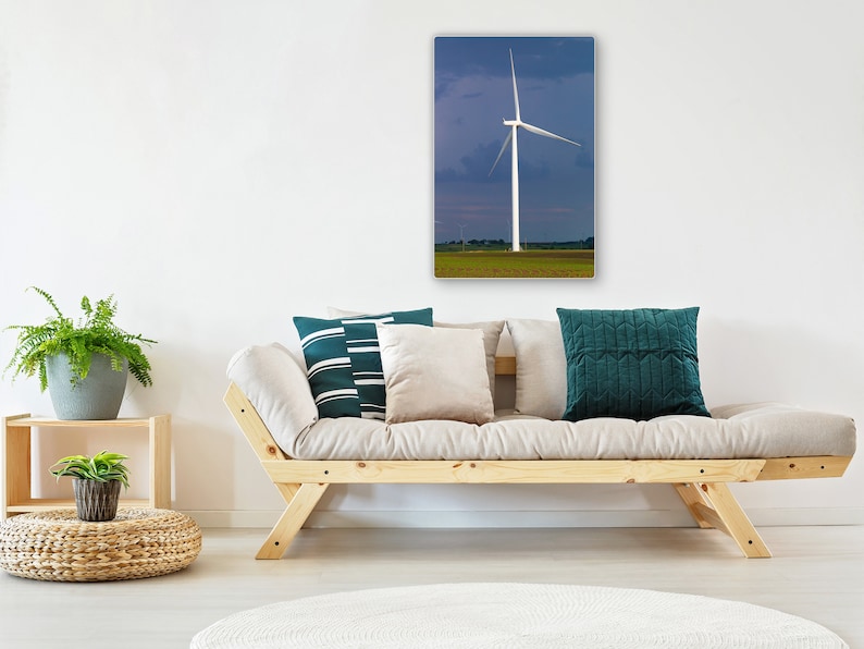 May include: A white wind turbine with three blades stands tall against a blue and purple sky. The turbine is in a field of green grass. The image is a photograph of a canvas print.