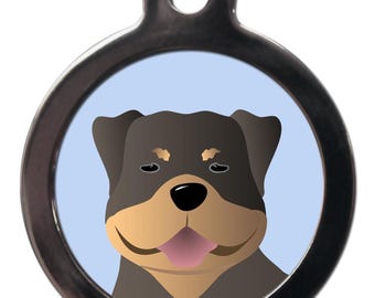 May include: A round silver dog tag with a blue background and a cartoon Rottweiler dog with brown fur and a pink tongue sticking out.