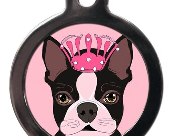Peut inclure: Une médaille ronde en argent avec un fond rose et un Boston Terrier noir et blanc portant une couronne rose avec des bijoux blancs.