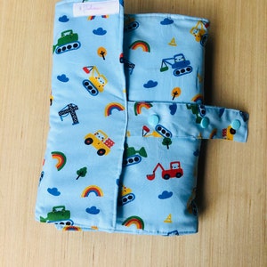 May include: A blue changing mat with a construction vehicle and rainbow pattern. The mat has a snap closure and a label that says "Handmade".