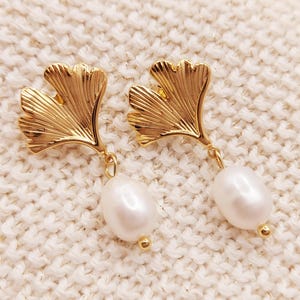 May include: Gold tone earrings with a ginkgo leaf design and a pearl drop.