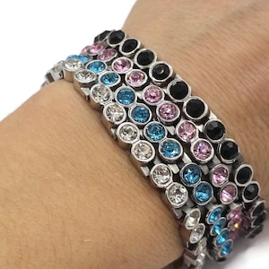 Könnte beinhalten: Ein Set aus vier Armbändern mit silbernen Metallgliedern und bunten Kristallsteinen. Die Armbänder haben schwarze, rosa, blaue und klare Steine.