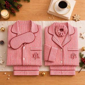 May include: Two sets of red and white striped pajamas with long sleeves and button-down fronts. One set includes a matching sleep mask, and the other includes a matching scrunchie. Both shirts feature a monogrammed pocket on the left side.