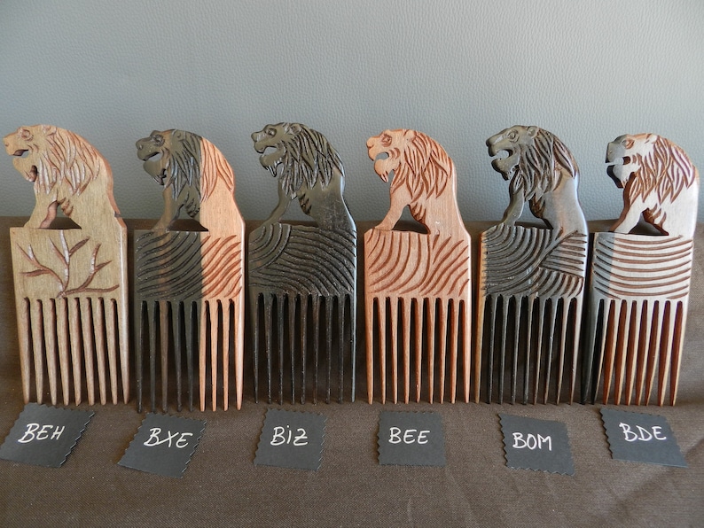 May include: Six wooden combs with lion head handles. The combs are in different shades of brown and black. The combs are labeled with the letters BEH, BXE, BIZ, BEE, BOM, and BDE.