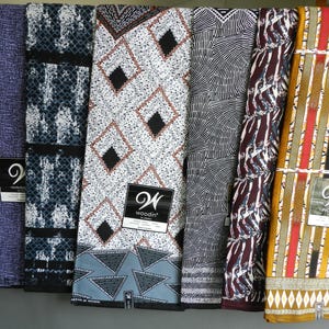 Könnte beinhalten: Sechs verschiedene Stoffmuster mit verschiedenen geometrischen Mustern. Die Stoffe sind in Blautönen, Schwarz, Weiß, Braun, Rot und Gelb. Die Muster sind mit dem Wort "Woodin" in einem schwarz-weißen Logo gekennzeichnet.