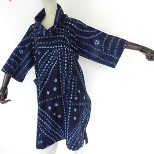 Puede incluir: Una túnica azul y blanca con cuello de pico y mangas tres cuartos.