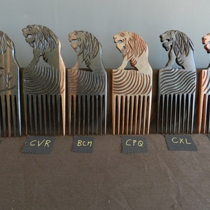May include: Six wooden combs with lion head handles. The combs are made of different types of wood and have different colors and patterns. The combs are labeled with the letters C2M, CVR, BCM, CPQ, CXL, and CAMT.